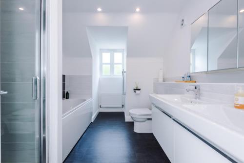 a white bathroom with two sinks and a shower at Grange House in Chester