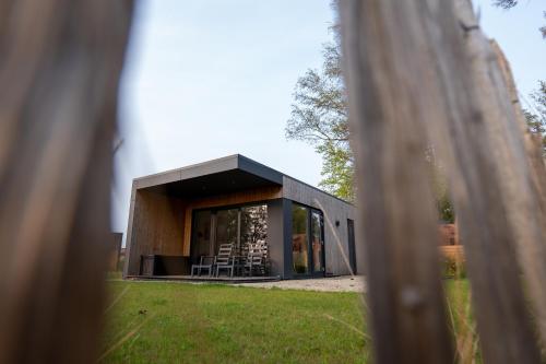 a black house with a window and some grass at Hofparken De Bergvennen in Lattrop