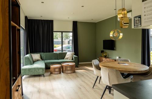 a living room with a green couch and a table at Hofparken De Bergvennen in Lattrop