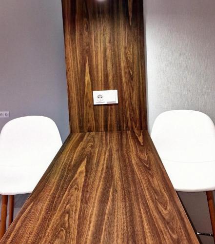 two white chairs and a wooden door with a sign on it at 40 m2 Confort apartament in Bălţi