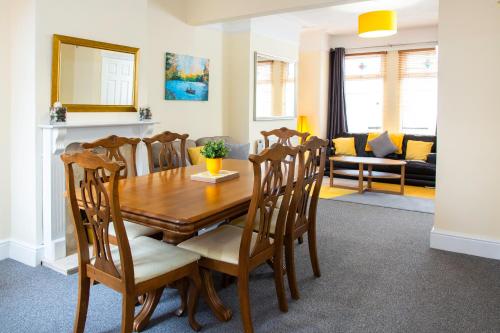 a dining room with a wooden table and chairs at 3 Bedroom House, Free Parking and Self Check In in Litherland