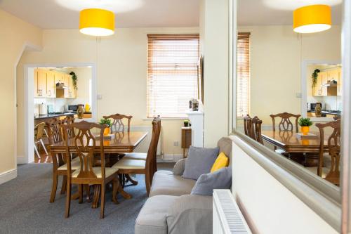 a dining room and living room with a table and a couch at 3 Bedroom House, Free Parking and Self Check In in Litherland