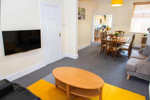 a living room with a table and a couch at 3 Bedroom House, Free Parking and Self Check In in Litherland