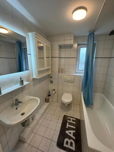 a bathroom with a sink and a tub and a toilet at Alex Apartments 3 in Solingen