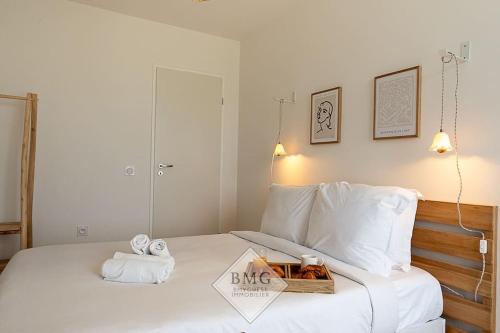 - une chambre avec un lit blanc et un plateau de serviettes dans l'établissement Rhapsodie Disneyland appartement, à Chessy