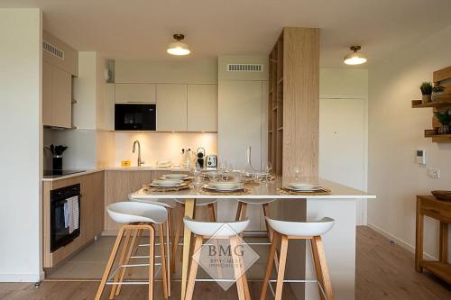 une cuisine avec un îlot et des tabourets de bar dans l'établissement Rhapsodie Disneyland appartement, à Chessy
