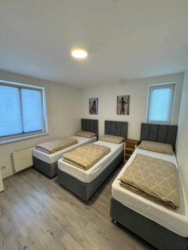 a room with three beds in it at Alex Apartments 3 in Solingen