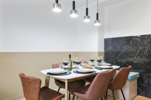 - une table à manger avec des chaises et des verres à vin dans l'établissement Bluestay 85 - Superbe appartement à Paris, à Paris