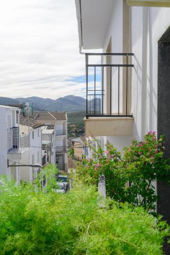 a white building with a balcony and some plants at AstArte Guesthouse in Castillo de Locubín
