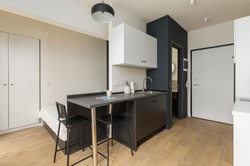 a kitchen with a black island and white cabinets at boat house - near Papafi metro station in Thessaloniki