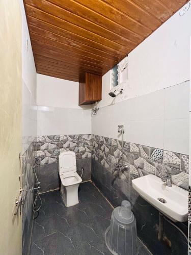 a bathroom with a toilet and a sink at Wildwings hotel in Hyderabad
