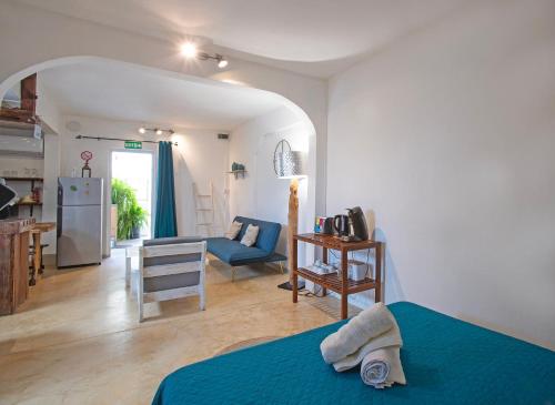 a bedroom with a blue bed and a living room at Sam & Chlo Studio & Appartment - Grand Baie - Mauritius in Grand Baie