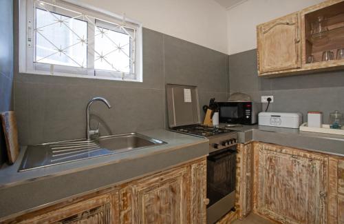 a kitchen with a sink and a stove and a window at Sam & Chlo Studio & Appartment - Grand Baie - Mauritius in Grand Baie