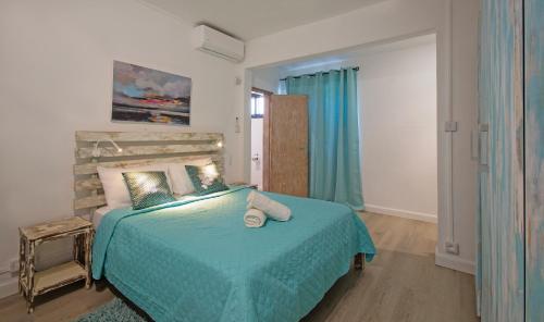 a bedroom with a bed with a blue comforter at Sam & Chlo Studio & Appartment - Grand Baie - Mauritius in Grand Baie