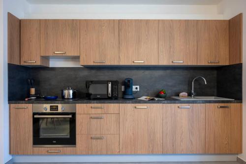 une cuisine avec des armoires en bois et un évier dans l'établissement Apartment Le Nid, aux Gets