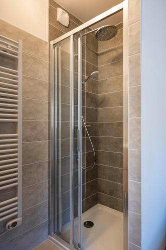 une douche avec une porte vitrée dans une salle de bain dans l'établissement Apartment Le Nid, aux Gets