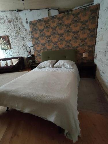 un lit dans une chambre avec un mur dans l'établissement La Chamade en Beaujolais, à Anse
