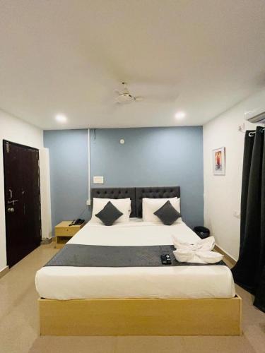 a bedroom with a large bed with a blue wall at Wildwings hotel in Hyderabad