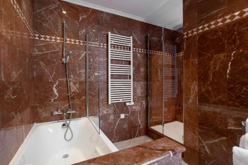 a bathroom with a bath tub and a shower at Westminster Hotel & Spa Nice in Nice