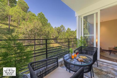a patio with a table and chairs on a balcony at The BlackPearl Hillcrest in Kasauli