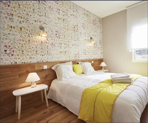 - une chambre avec 2 lits et un mur orné de fleurs dans l'établissement Appartement T3 AU VIEUX PORT, à Saint-Quay-Portrieux