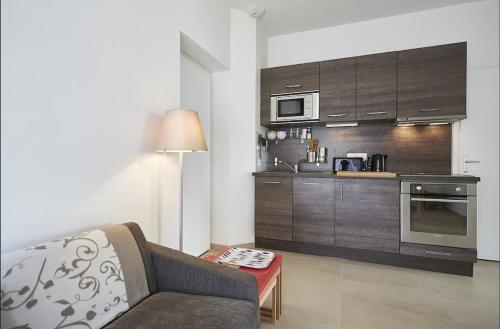 un salon avec un canapé et une cuisine dans l'établissement Appartement T3 AU VIEUX PORT, à Saint-Quay-Portrieux