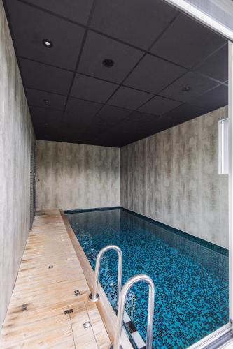 une piscine intérieure avec un plancher en bois et une piscine dans l'établissement Gîte, Spa Kyo-alpes, piscine intérieure privée prés de Chambéry, à Saint-Cassin