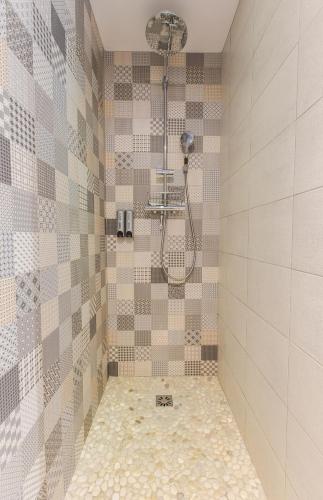 La salle de bains est pourvue d'une douche et d'un mur carrelé. dans l'établissement Gîte, Spa Kyo-alpes, piscine intérieure privée prés de Chambéry, à Saint-Cassin