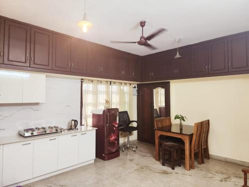 eine Küche mit einem Kühlschrank und einem Tisch in der Unterkunft Cosy & homely full cottage in Kochi