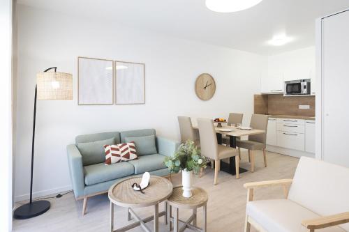 un salon avec un canapé et une table dans l'établissement OVELIA Angers - Les Jardins d'Arborescence, à Angers