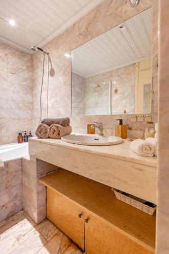 une salle de bain avec un lavabo et un miroir dans l'établissement Arc de triomphe studio charme authentique, à Paris
