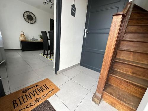 a hallway with a blue door and a welcome mat at Maison de ville Chauny in Chauny