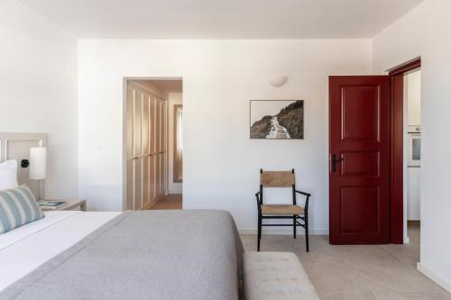 a bedroom with a bed and a red door at Vedema, a Luxury Collection Resort, Santorini in Megalokhori
