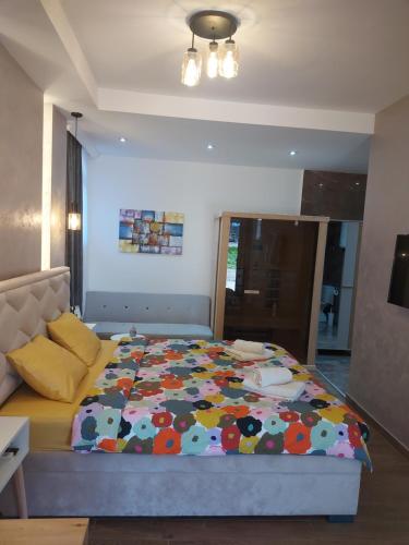 a bedroom with a bed with a colorful comforter at Stan na dan PREMIUM 1 Obrenovac in Obrenovac