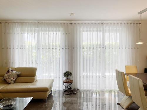 ギーセンにあるLuxury Wohnung mit Großem Bett und Schlafsofa Luxuriös Ausgestattet mit schöne Terrasse und Garten!のリビングルーム(白いカーテン、ソファ付)