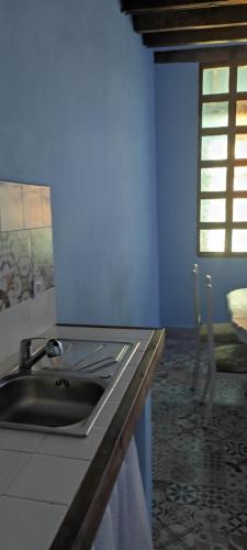 cocina azul con fregadero y ventana en La Ballena Gris, en Los Silos