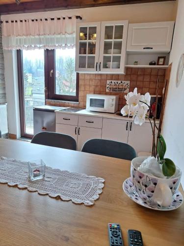 a kitchen with a table with a bowl of flowers on it at Holiday Home Lana in Fužine