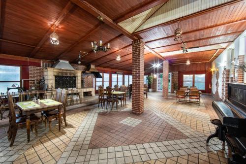 a large dining room with wooden ceilings and tables at Hotel Armales in Stakčín