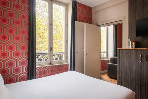 Una cama o camas en una habitación de Hôtel Helzear Champs-Elysées