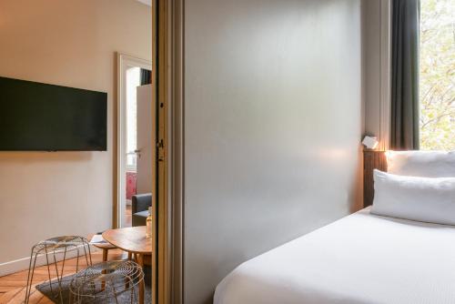 Una cama o camas en una habitación de Hôtel Helzear Champs-Elysées