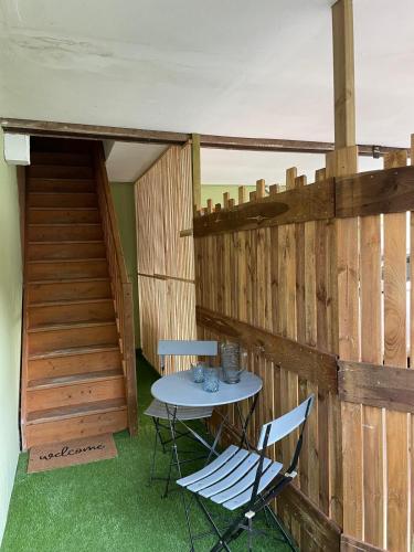 a table and chairs in a room with a wooden wall at Lilas, Dahlia, Palme Bleue in Saint-Aignan