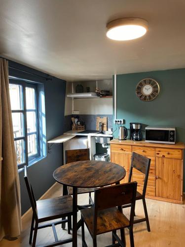 a kitchen with a wooden table and chairs and a table at Lilas, Dahlia, Palme Bleue in Saint-Aignan