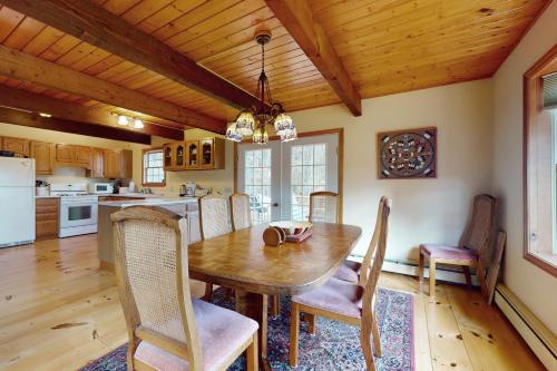 a kitchen and dining room with a wooden table and chairs at Green Mountain Sunrise in Dover