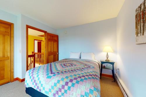 a bedroom with a bed and a table with a lamp at Green Mountain Sunrise in Dover