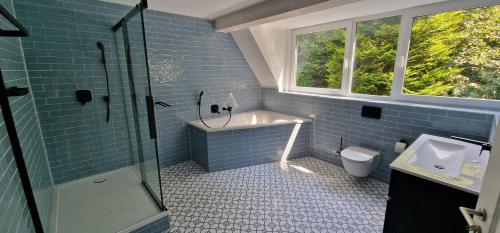 a blue bathroom with a sink and a toilet at Ruhiges Haus im Grünen mit Whirlpool & 3 Schlafzimmern nahe Messe Essen in Essen