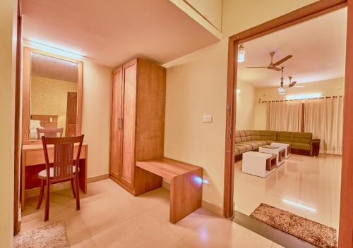 a living room with a table and a couch at Ushasree Wayanad Pool Resort by VOYE HOMES in Ambalavayal