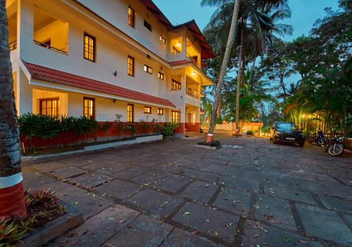 a building with a car parked in front of it at Ushasree Wayanad Pool Resort by VOYE HOMES in Ambalavayal
