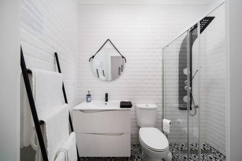 a white bathroom with a toilet and a mirror at Stylish apartment old town in Portimão
