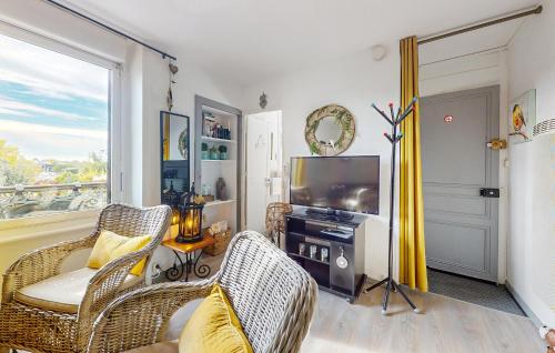 un salon avec des chaises en osier et une télévision dans l'établissement Proche Mer, à Ploemeur