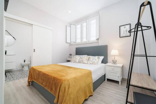 a bedroom with a bed with a yellow blanket on it at Stylish apartment old town in Portimão